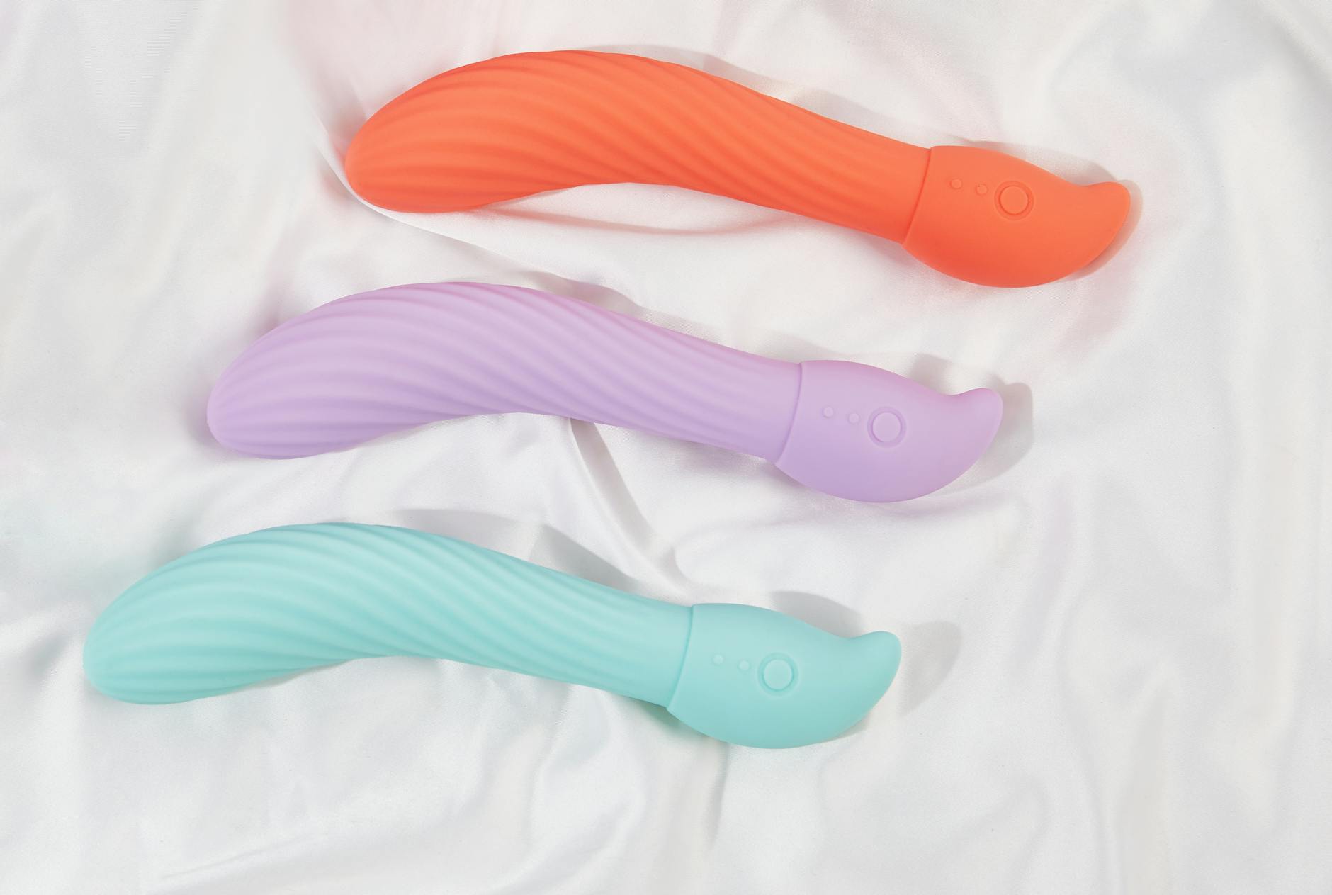 Woman holding blue and pink silicone vibrators thoughtfully, representing reclaiming desire.