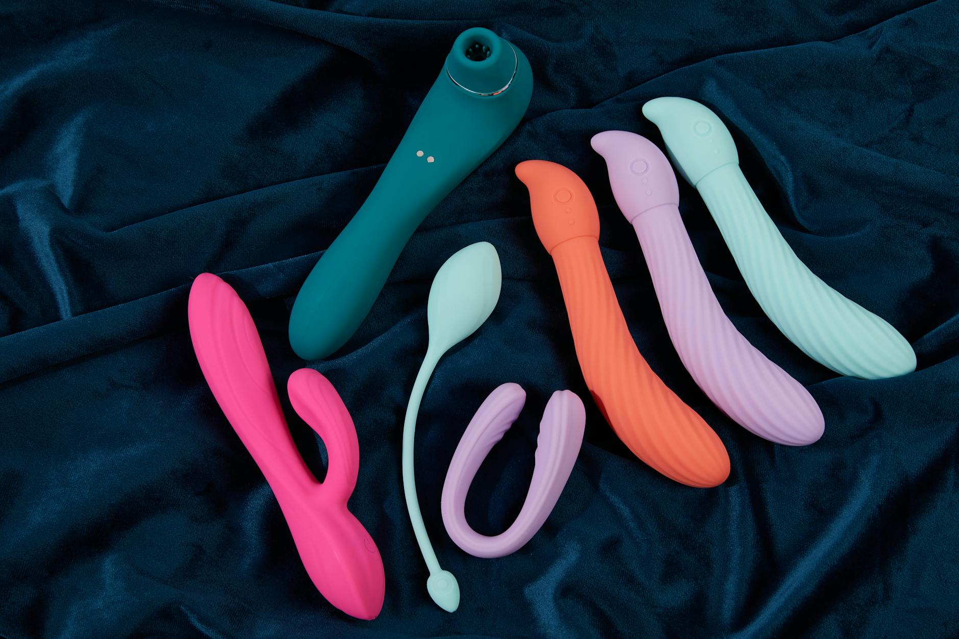 A couple standing together indoors, holding a modern vibrator, representing intimate connection and sexual wellness over 40.