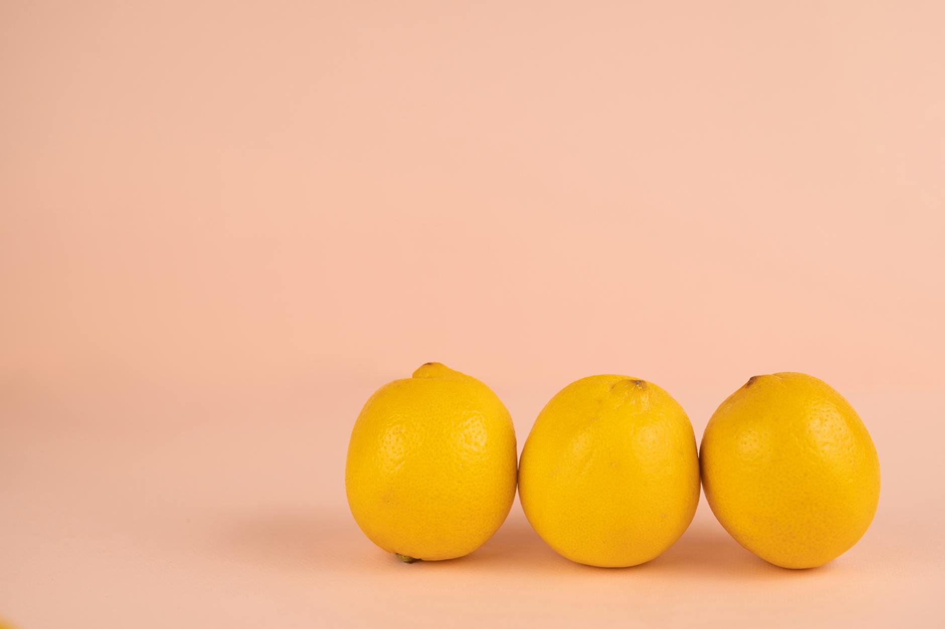 Bright ripe lemons on a soft pastel background, symbolizing gentle, refreshing pleasure