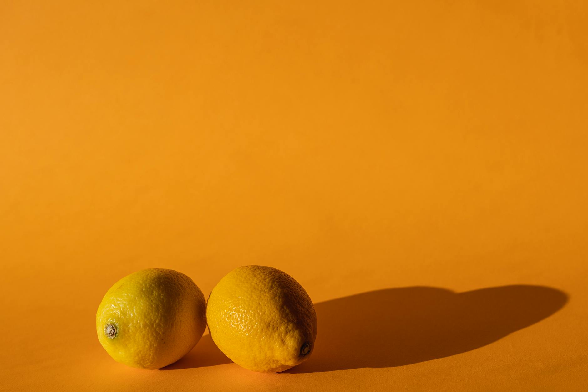 Ripe lemons on a bright yellow background, symbolizing sensory renewal and vitality